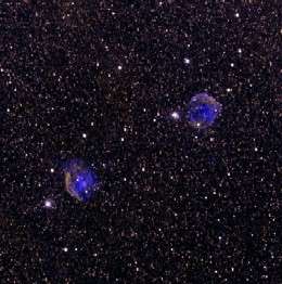 imagem com varias estrelas e duas nuvens de poeira violeta