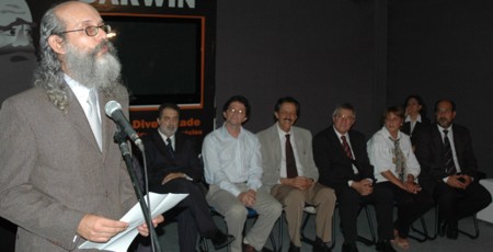 Professor Renato agradecendo seu premio e ao fundo homens assistindo ao discurso